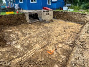 A blue house with a hole in the ground.