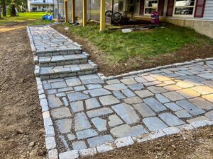 A stone walkway with steps in front of a house.