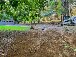 A dirt road with a bulldozer in the background.