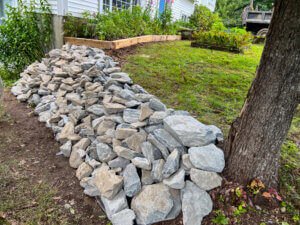 A rock wall in front of a house.