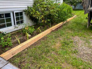 A wooden garden bed in front of a house.