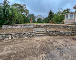 A backyard with a stone wall and steps.